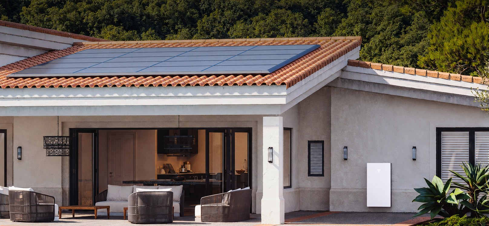Villa con impianto fotovoltaico sul tetto e batteria Tesla Powerwall a parete: installazione Tesla Energy