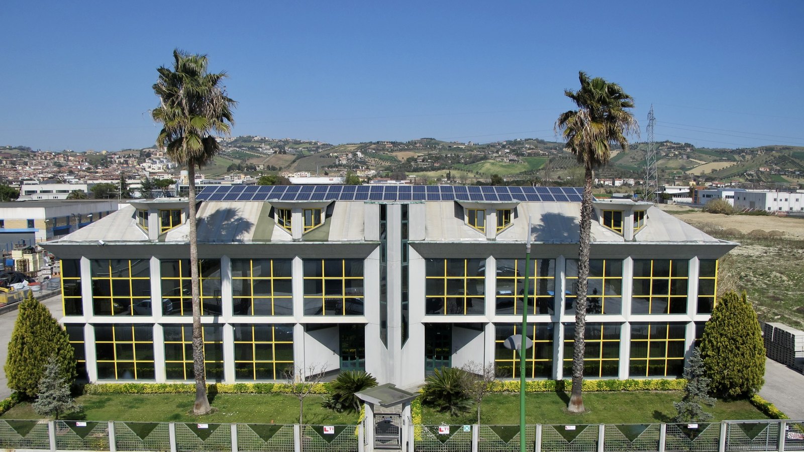 La sede di STILCA Energy a Monteprandone vista dall'alto, con l'impianto fotovoltaico sul tetto e le colline del Piceno sullo sfondo