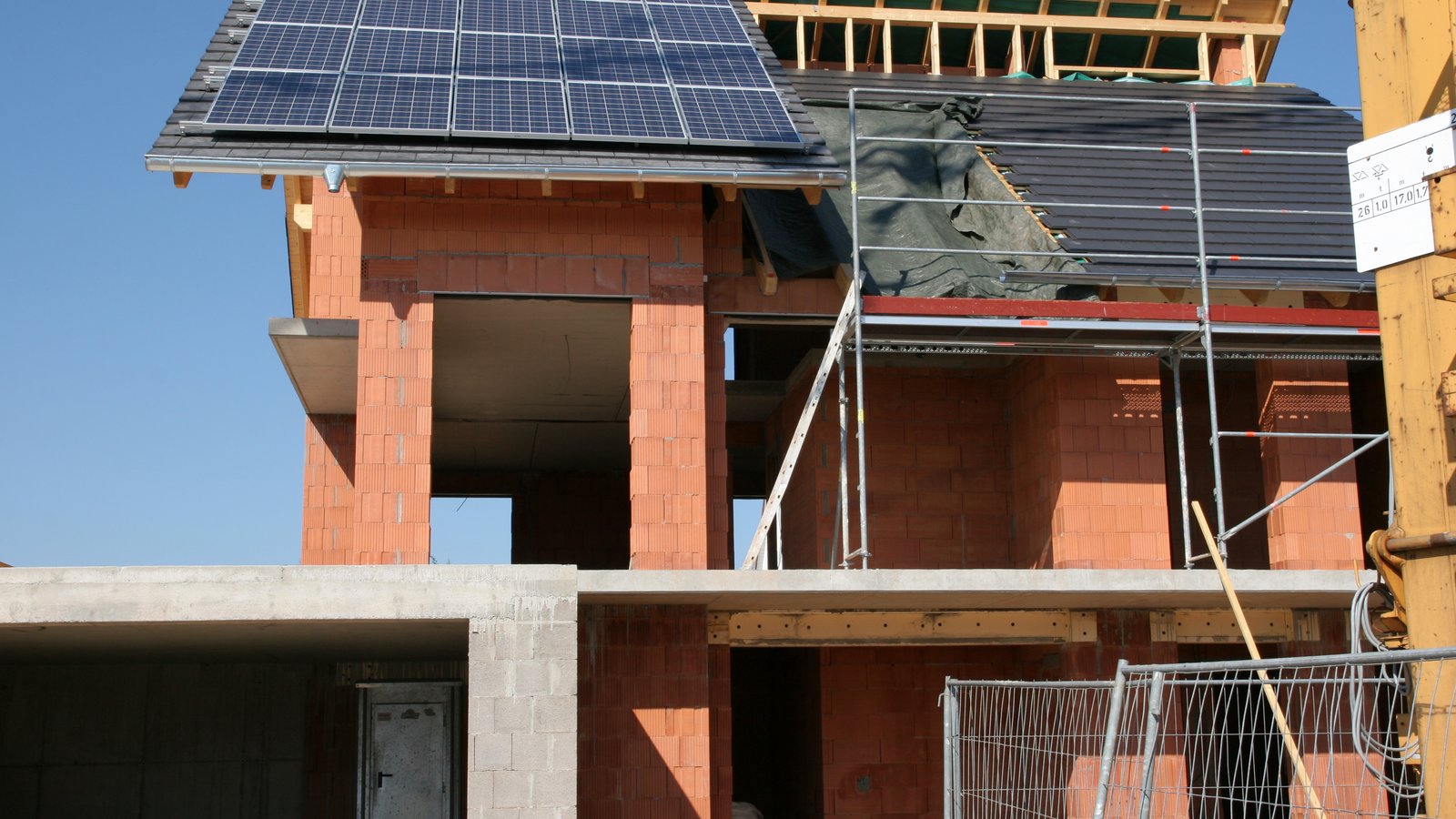 Casa di nuova costruzione ancora al grezzo con i moduli fotovoltaici già installati sul tetto per rispettare l'obbligo del 60%