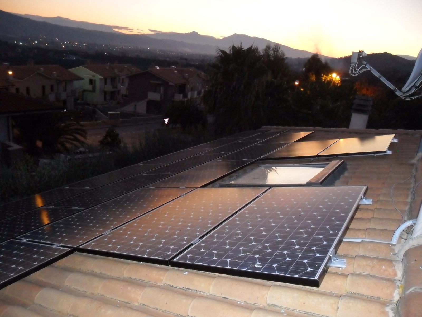 Tetto con moduli fotovoltaici al calare della sera, energia accumulata per la notte