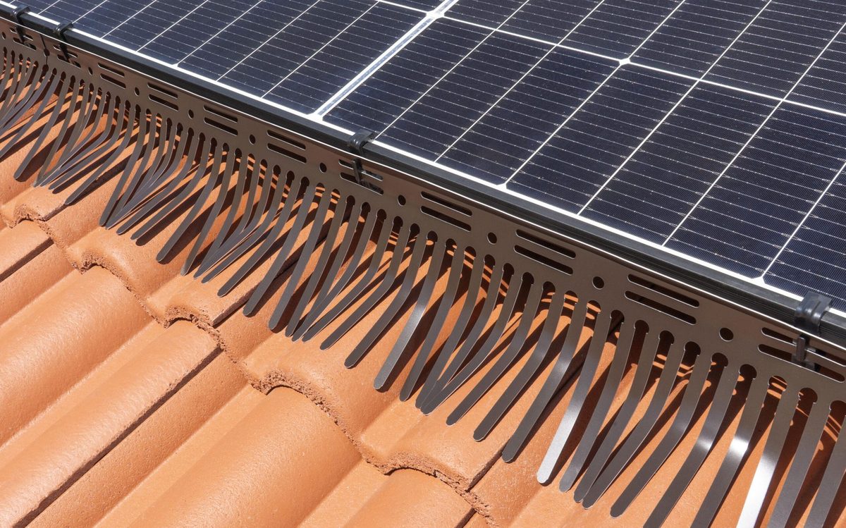 Barriera a pettine in alluminio preverniciato fissata al bordo dei moduli fotovoltaici su tetto in coppi