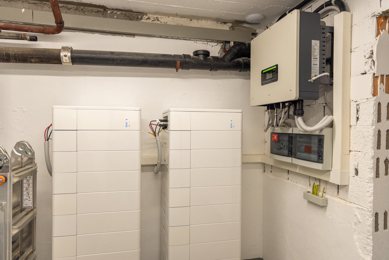 Due batterie di accumulo domestiche con inverter ibrido e quadro in un locale tecnico