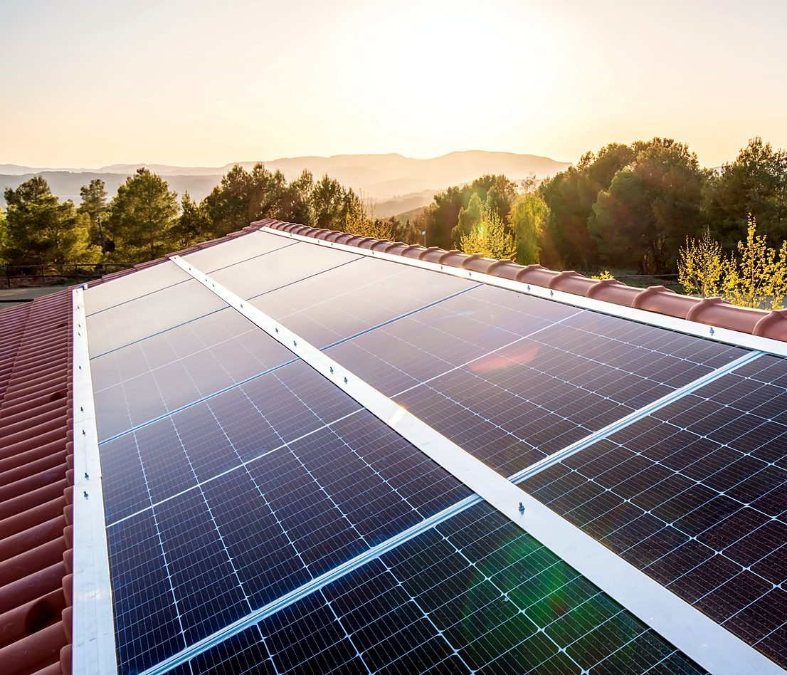 Impianto fotovoltaico sul tetto di una casa circondata da alberi