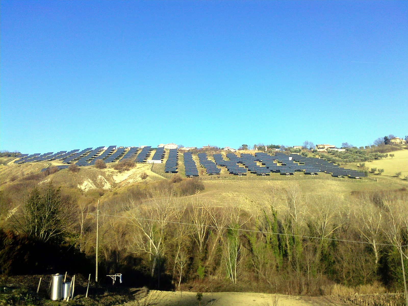 Impianto fotovoltaico a terra sulle colline sotto un cielo sereno