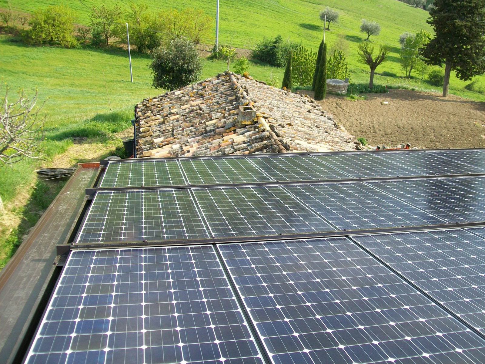 Moduli fotovoltaici su tetto di una casa immersa nel verde