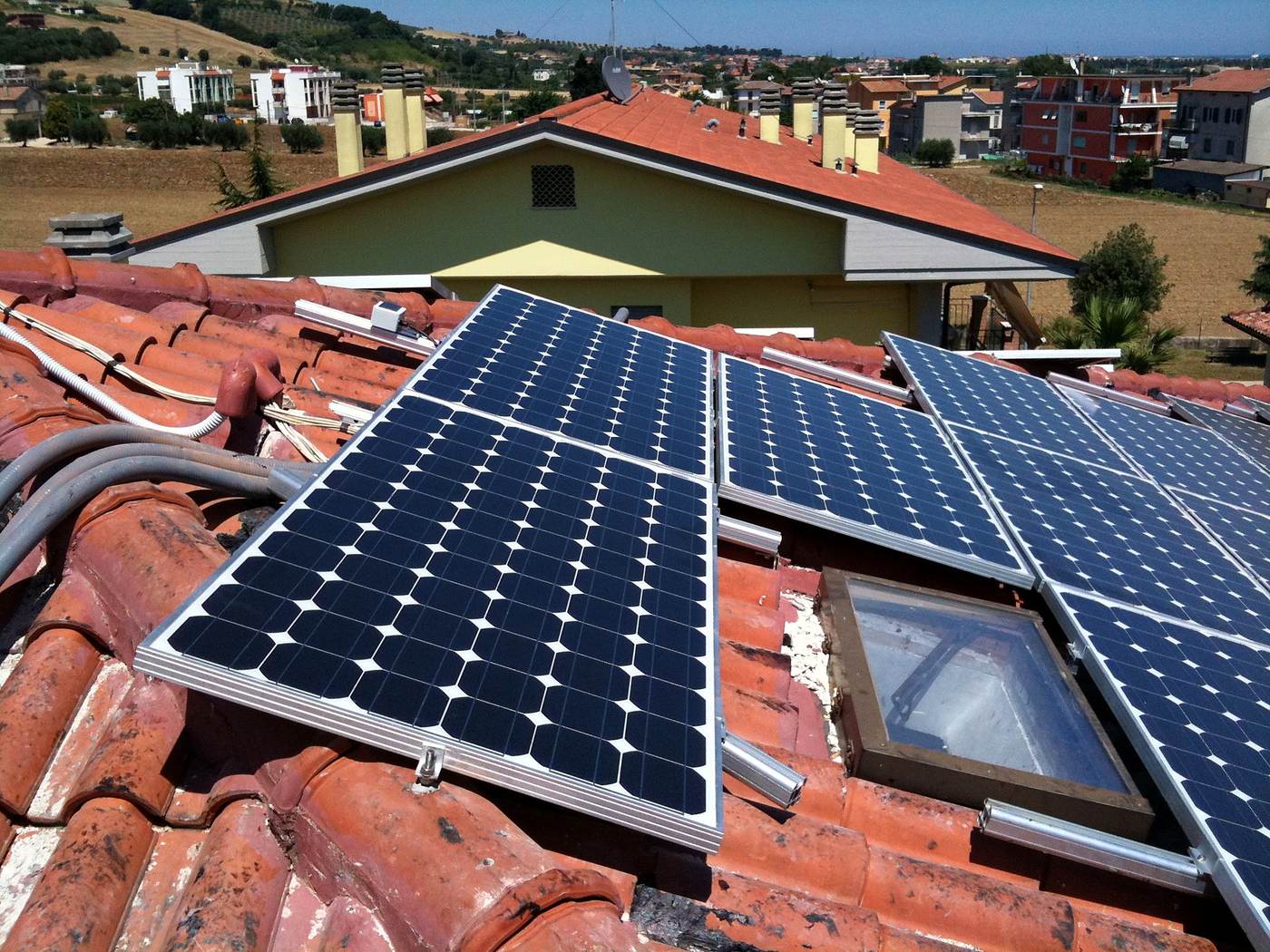 Moduli fotovoltaici a sbalzo su coppi rotti con lucernario incastrato tra i pannelli
