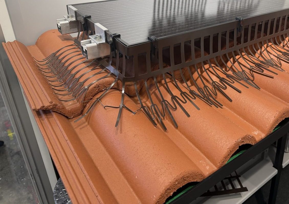 Barriera anti-piccioni a pettine metallico montata sul bordo di un modulo fotovoltaico su coppi