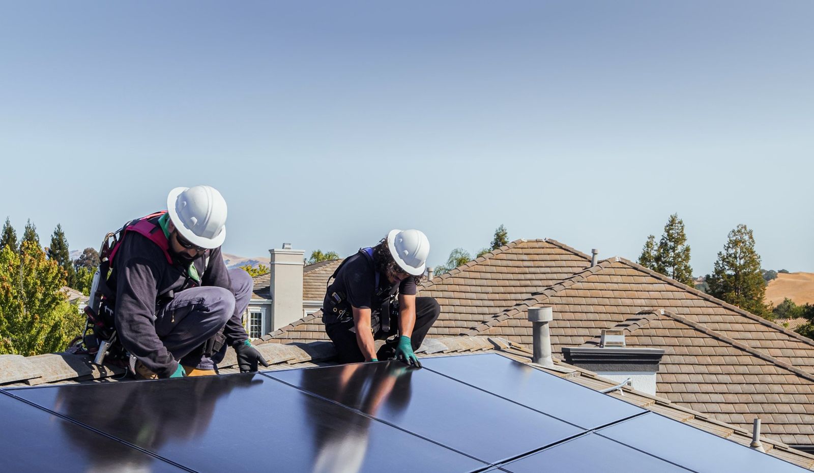 Installatori al lavoro sui pannelli di un tetto residenziale