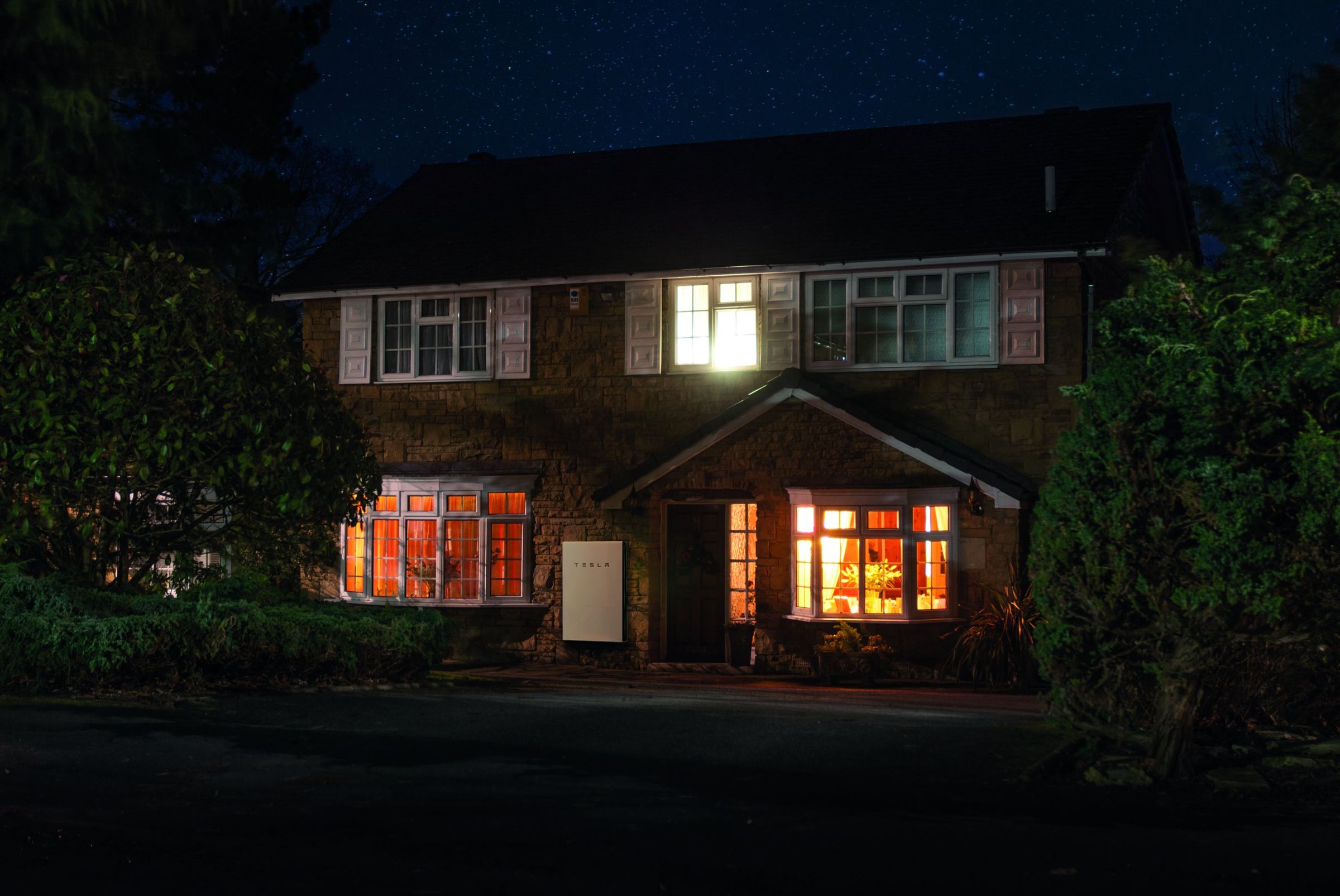 Casa illuminata di notte alimentata dalla batteria Tesla Powerwall
