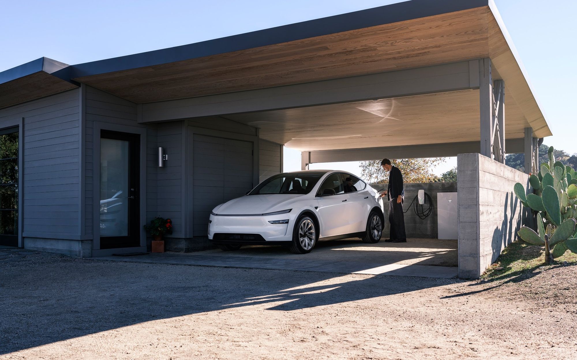 Auto Tesla in ricarica sotto la tettoia di casa con Wall Connector