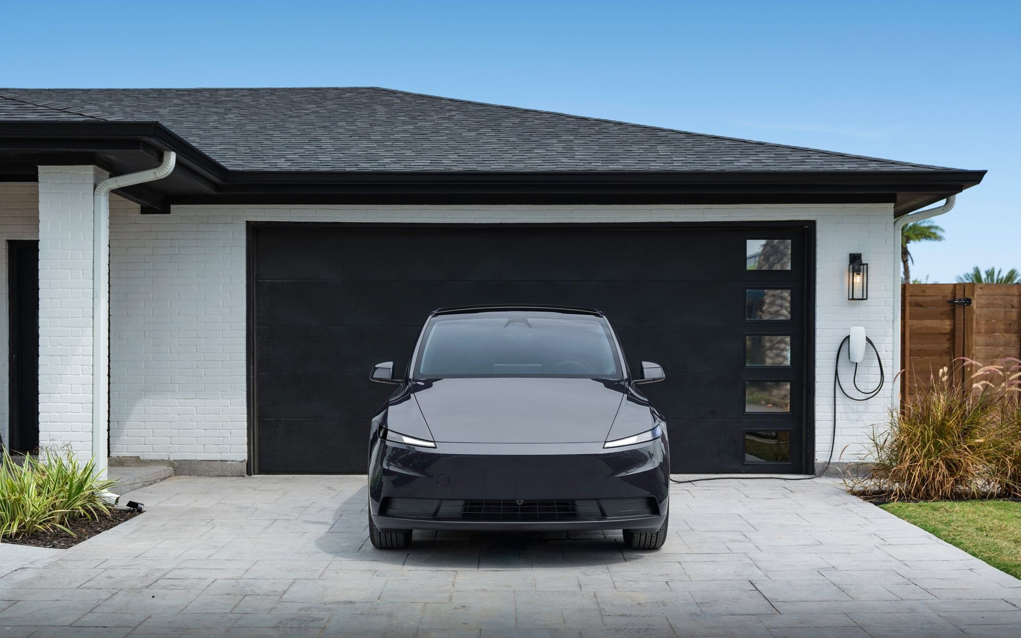 Garage moderno con auto Tesla in ricarica dal Wall Connector